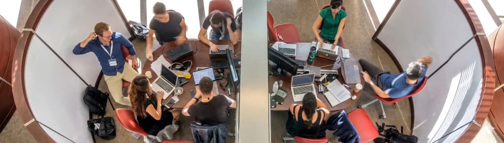 円形の学習ブースでノートPCを開き、グループで学習・議論する学生たち